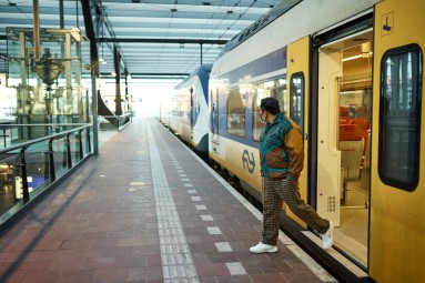 Ein Mann steigt aus einem gelben Zug aus.