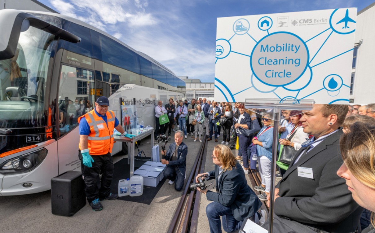 Outdoor display at InnoTrans with people and a train. Outdoor display at InnoTrans with people and a train.